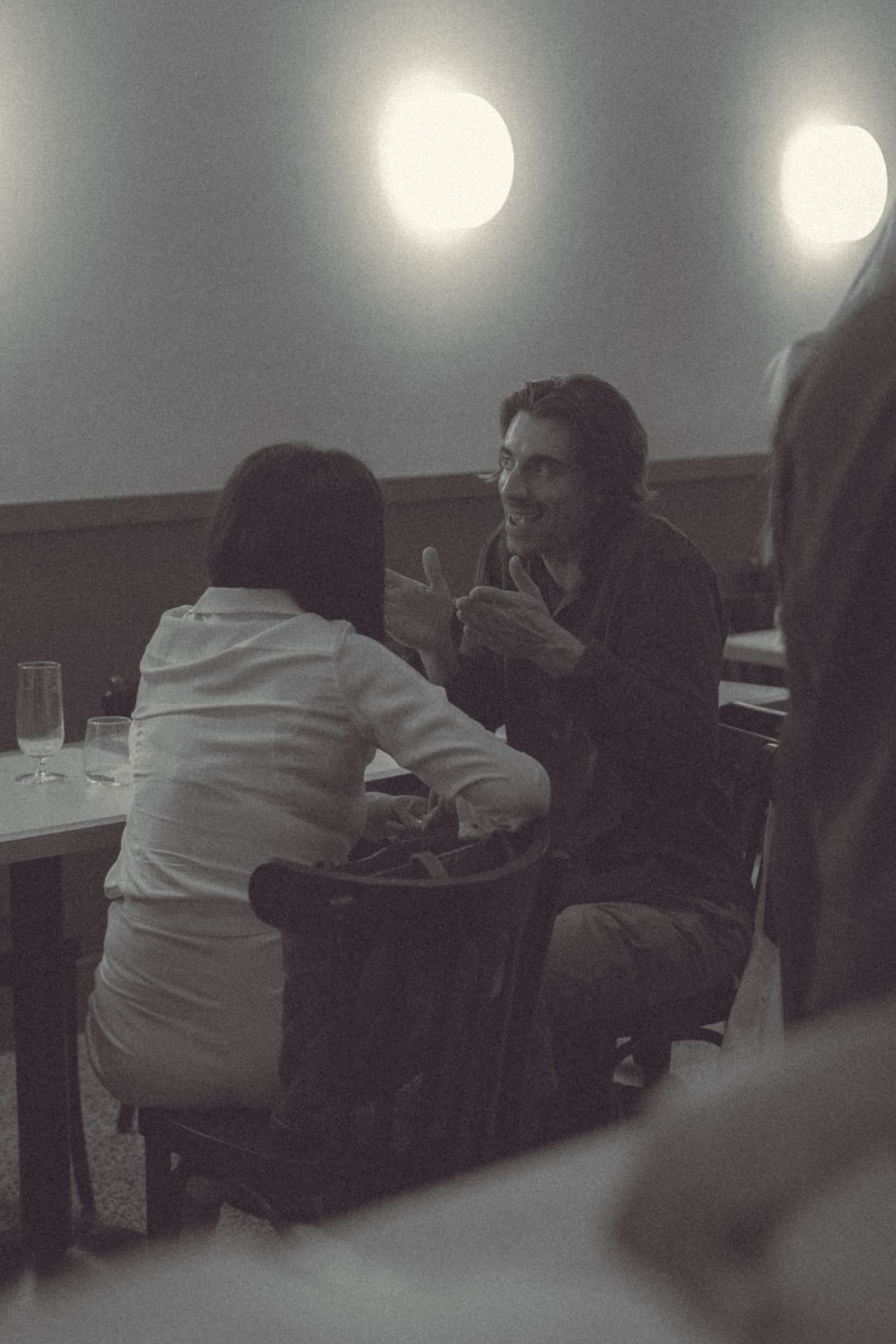 Dos invitados en conversación cercana con luz cálida en la quedada comunidad Sobremesa tech Madrid diálogo abierto