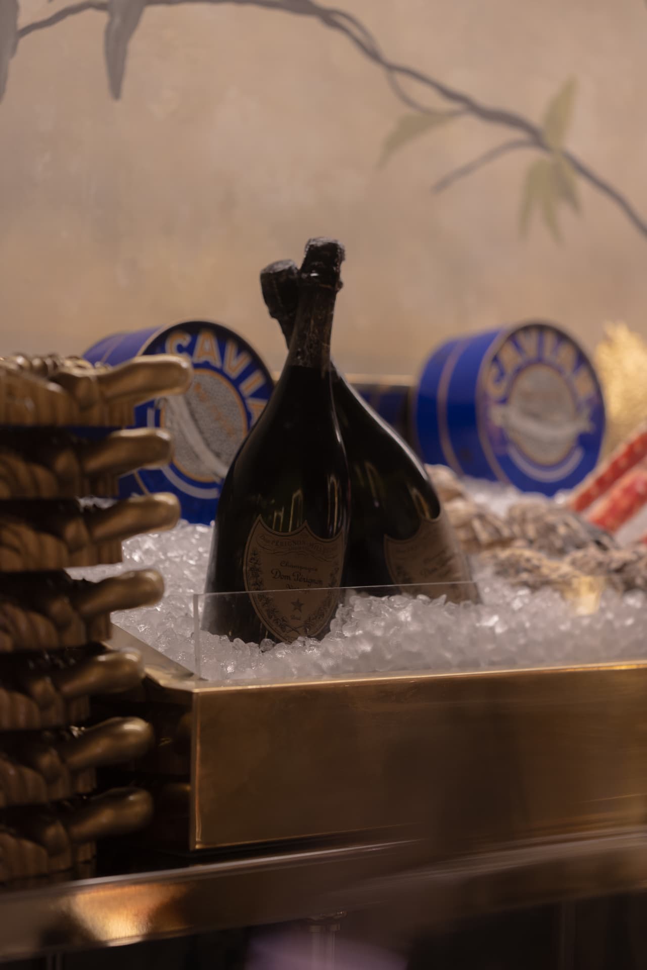 Botellas de Dom Pérignon y latas de caviar sobre hielo en el bistró de champagne y caviar de Manero