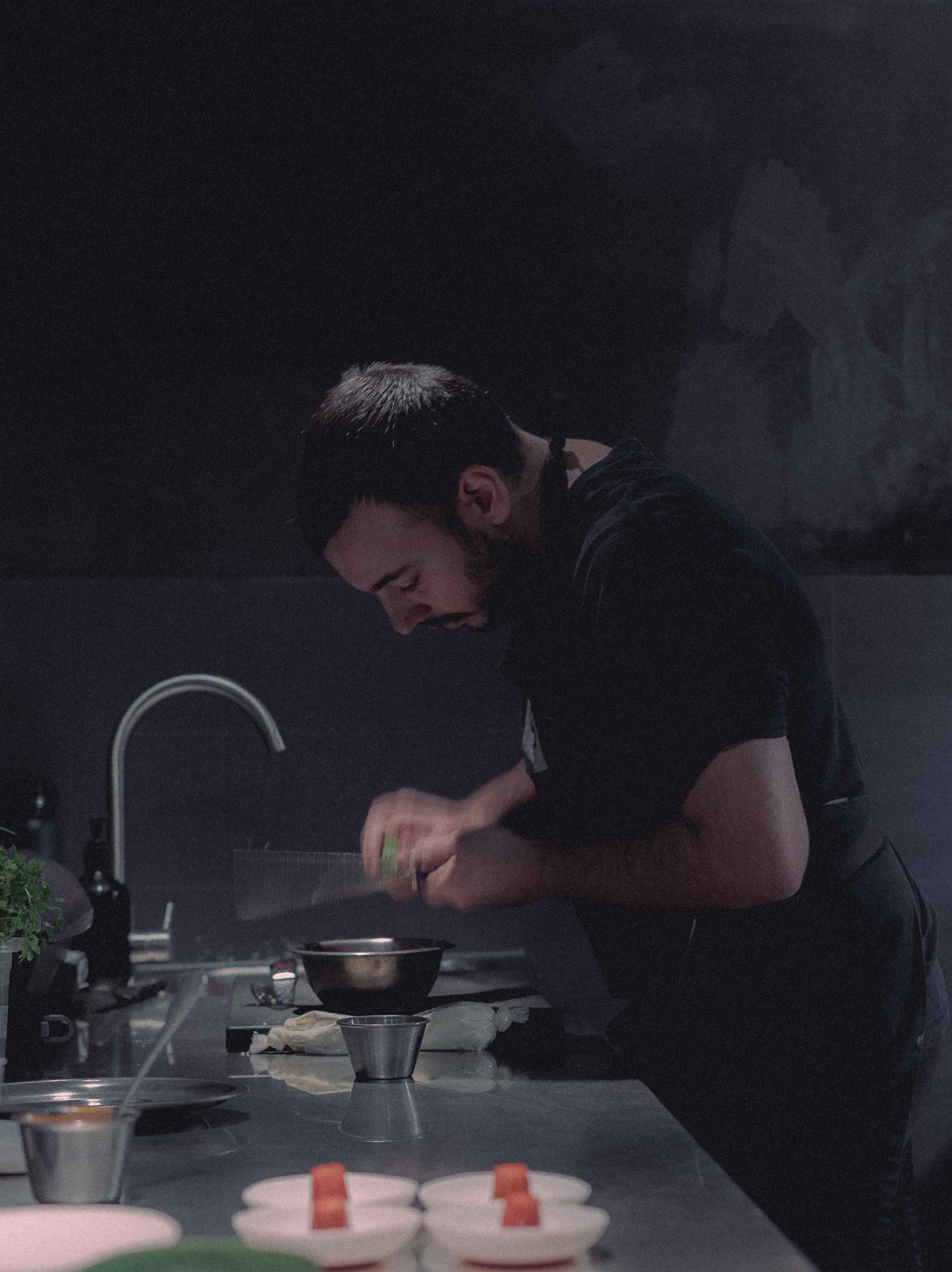 Chef concentrado en la preparación de un plato en la cocina de Gofio