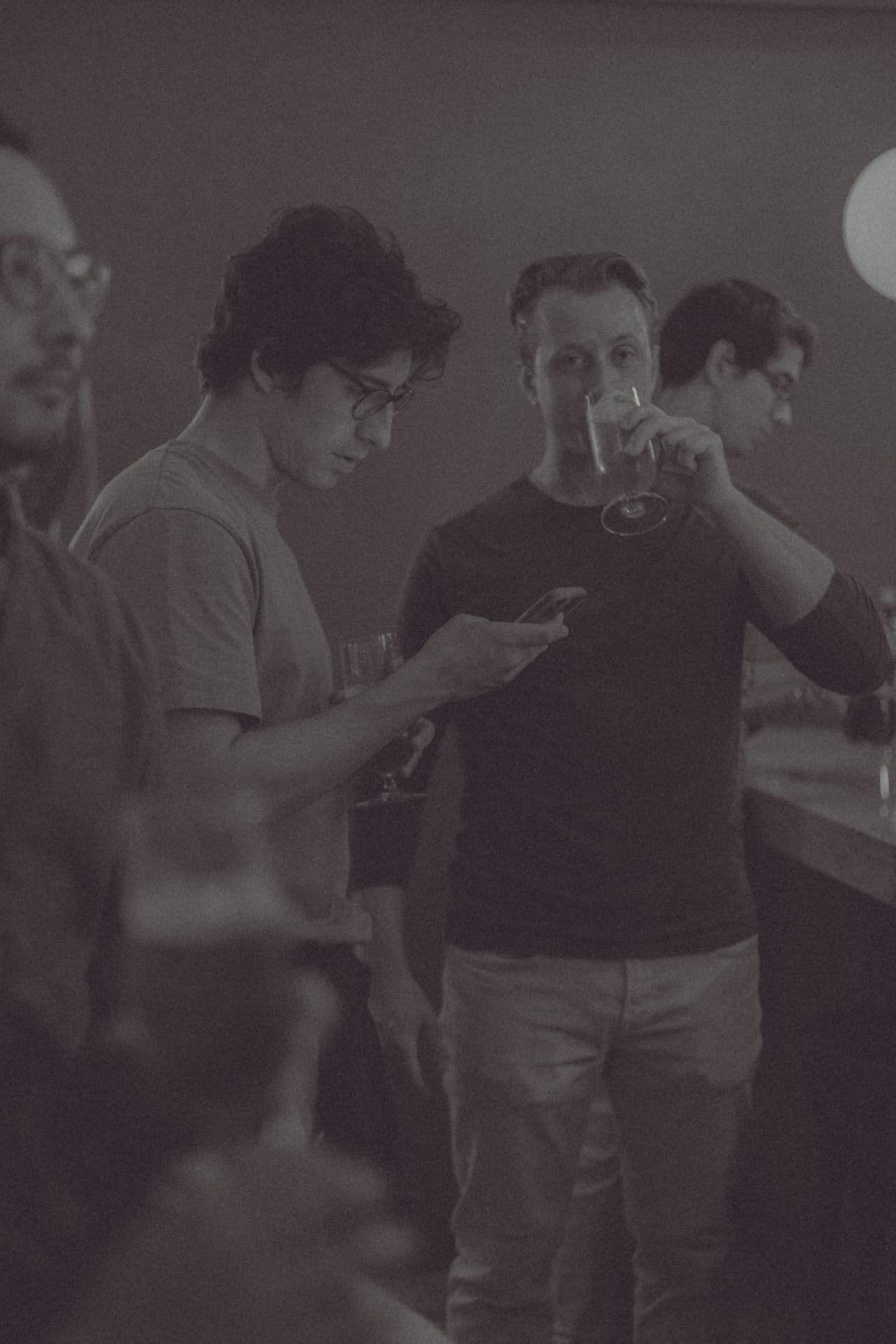 Grupo de asistentes con móvil y copa de vino en la quedada comunidad Sobremesa tech Madrid diálogo abierto