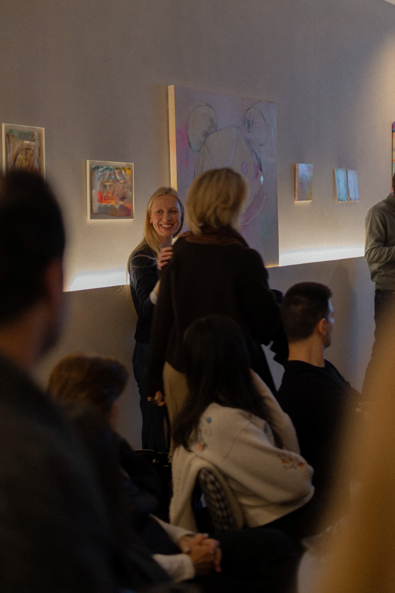 Anfitriona presentando frente a obras de arte en la segunda edición Sobremesa tech Madrid comunidad