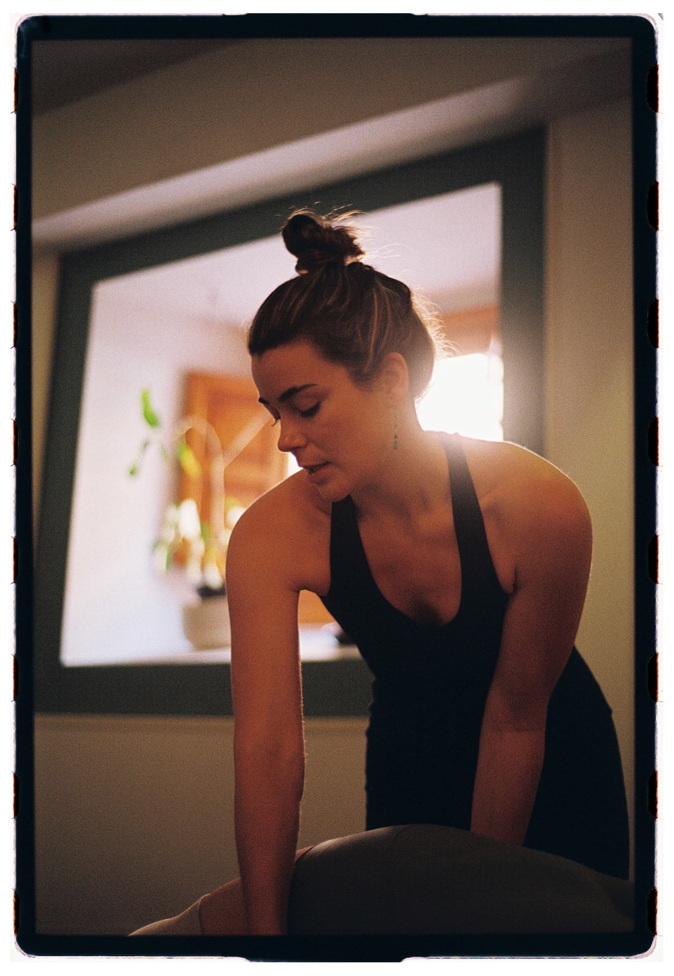 Retrato de Laura Fernández guiando la práctica junto a la ventana, práctica vinyasa fotografía analógica Madrid