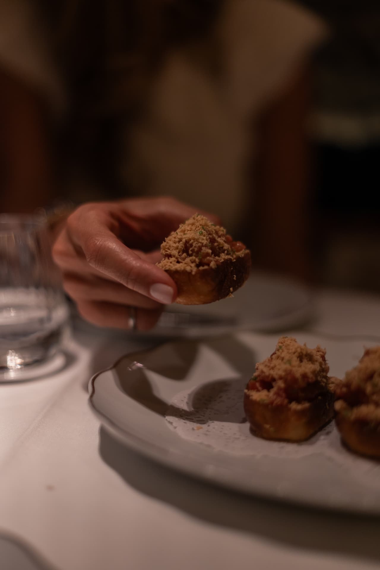 Comensal sosteniendo un brioche de tartar de atún en el bistró de Manero Marqués de Cubas