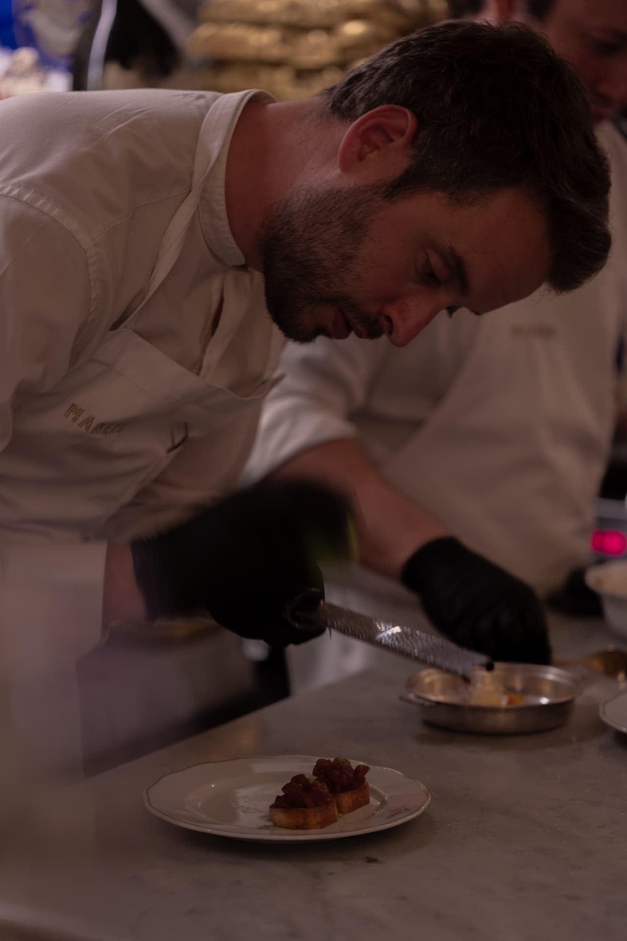 Chef Marc del equipo de Manero rallando en detalle sobre brioche de tartar