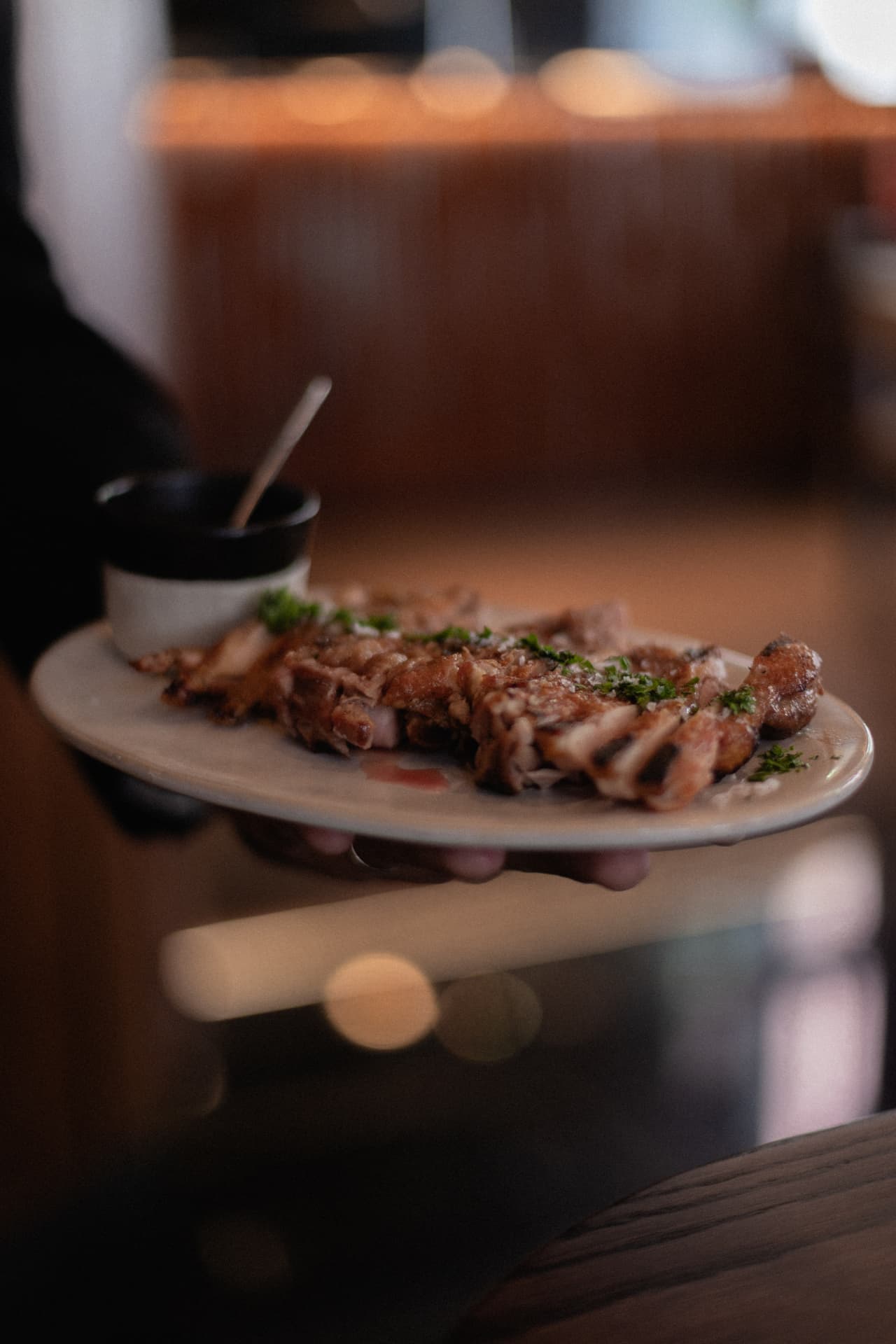 Carne a la brasa emplatada servida por camarero en Roostiq Bar Madrid