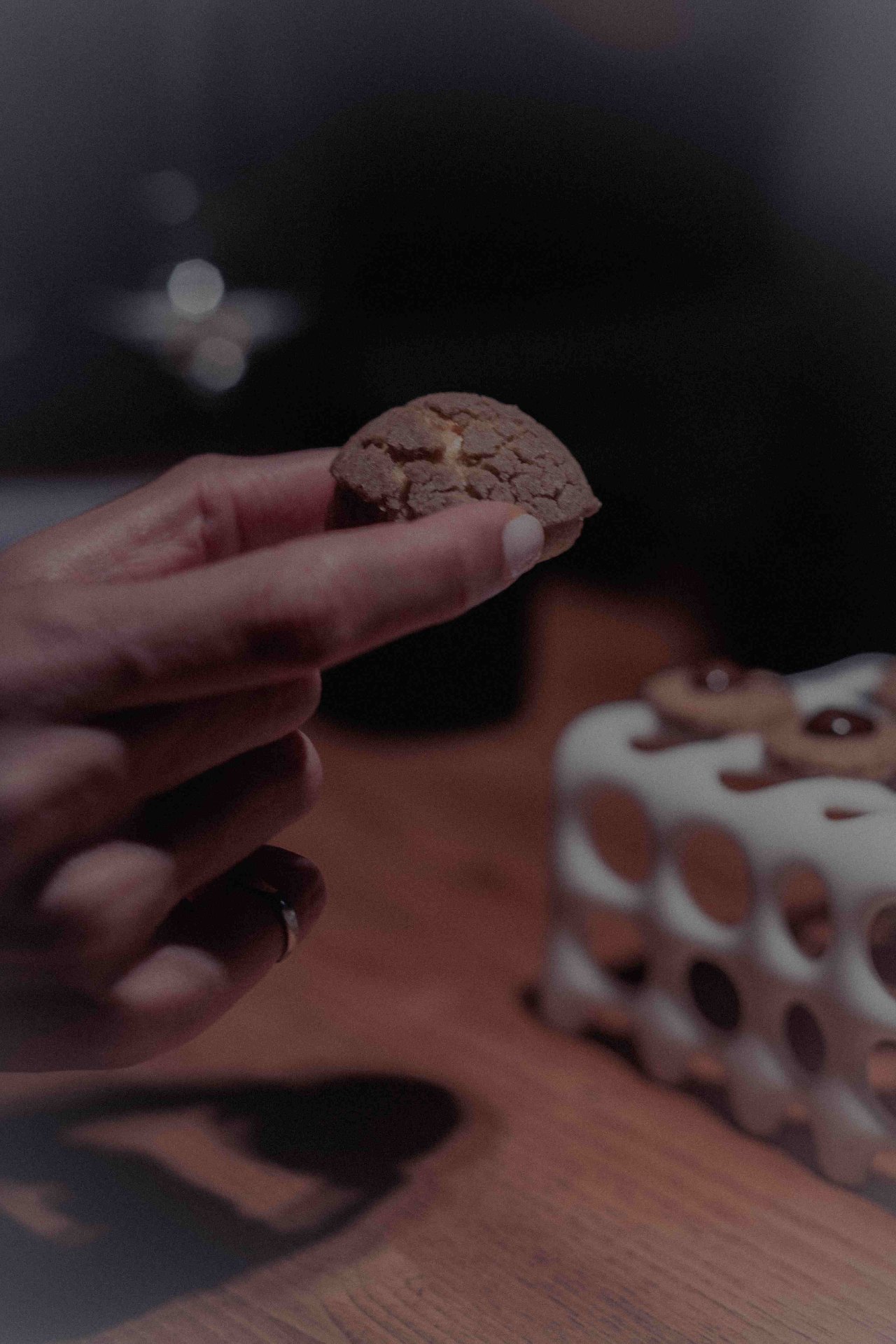 Mano sosteniendo una mignardise artesanal en la sobremesa de Gofio Madrid