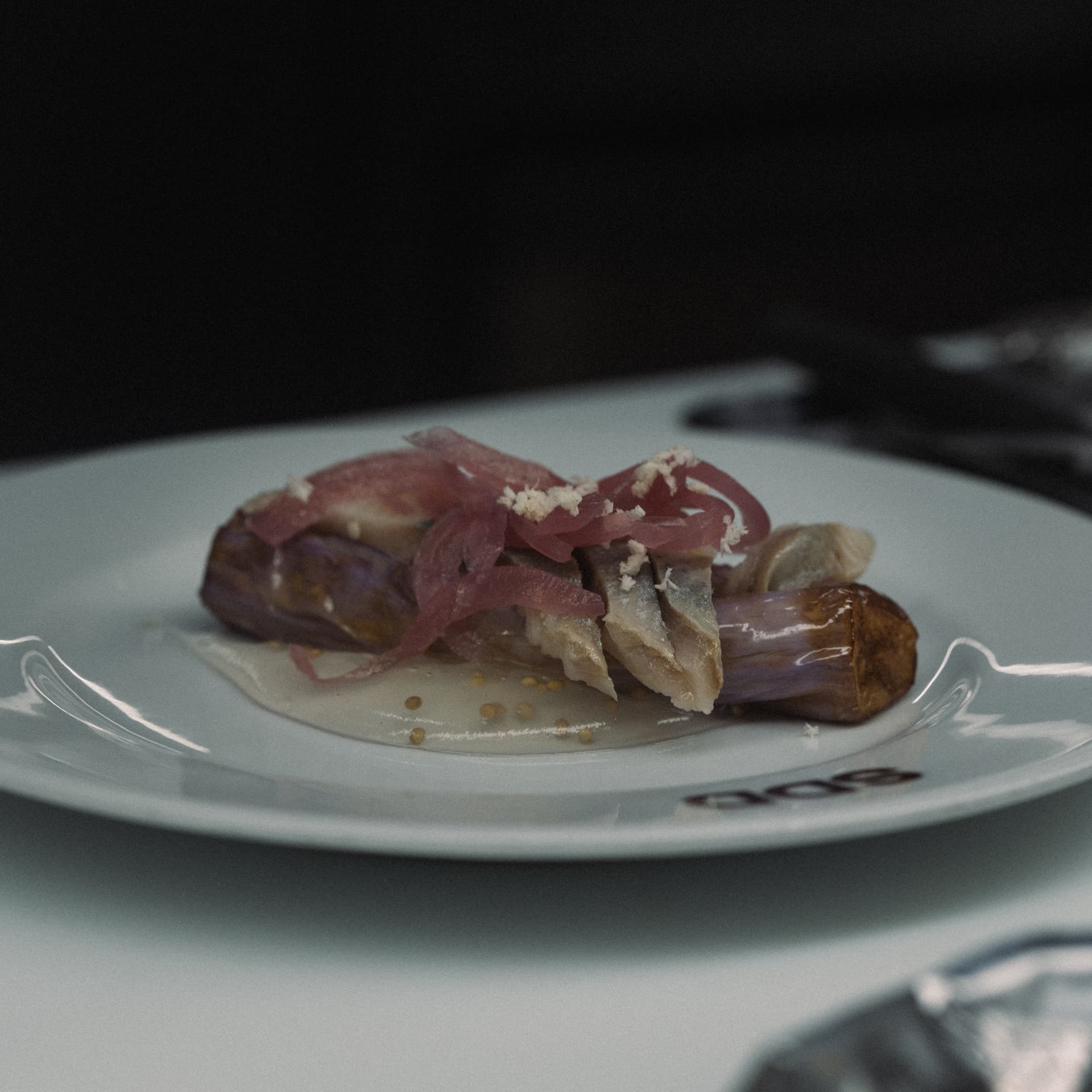 Caballa marinada con cebolla encurtida emplatada en barra en Sala de Despiece Madrid