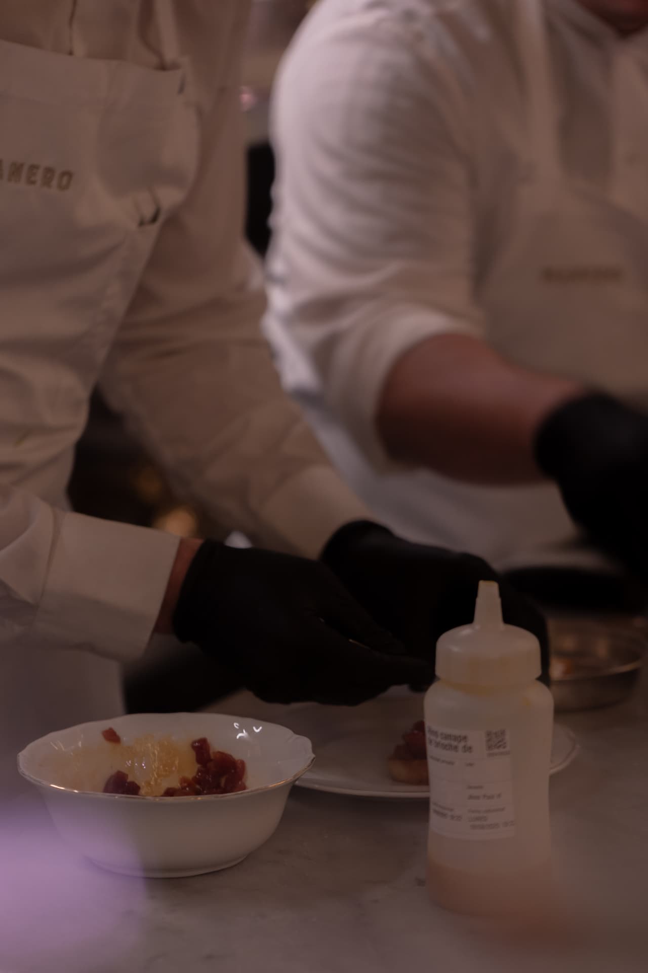 Cocineros de Manero en pleno emplatado con guantes negros en el pase