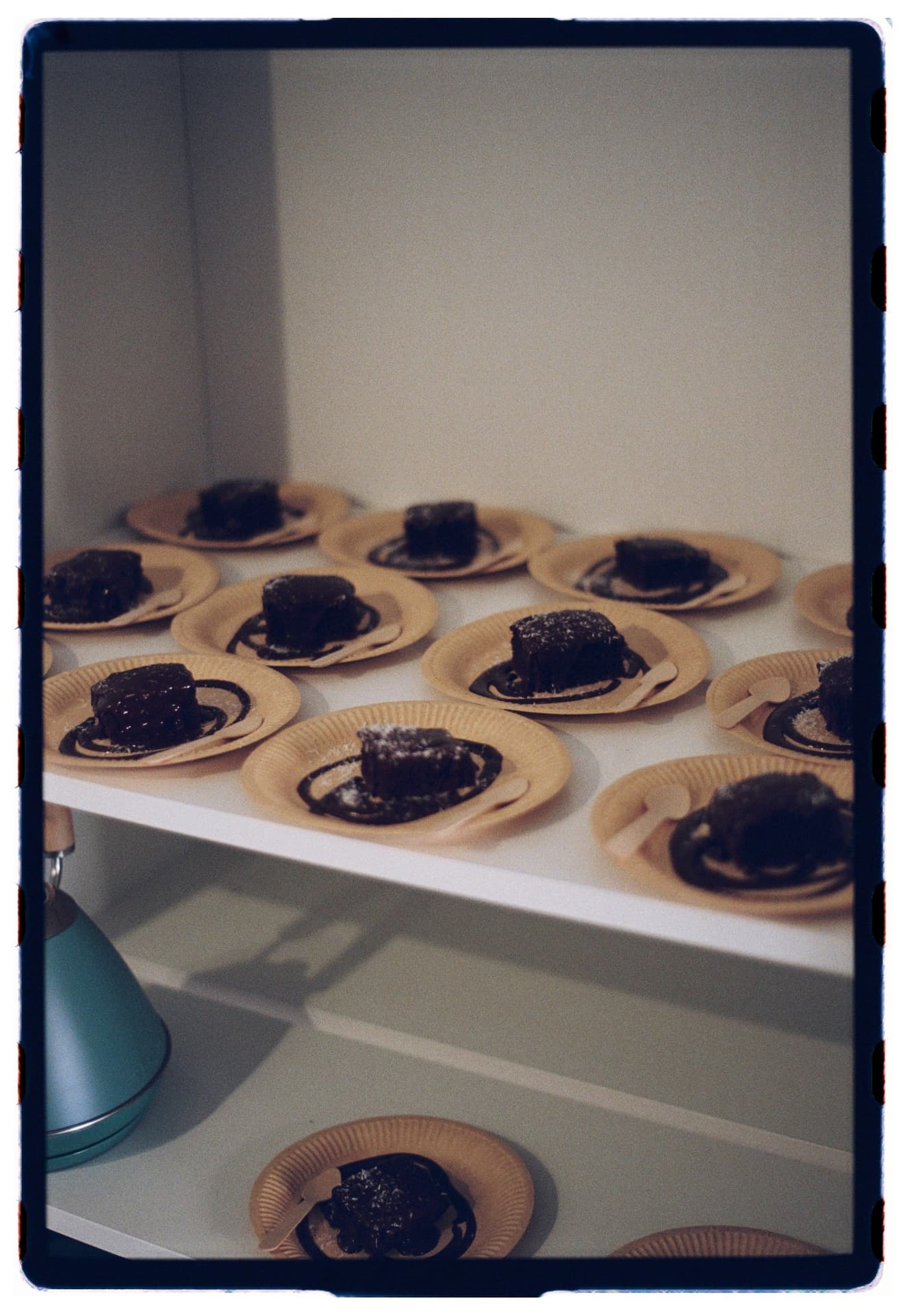 Brownies con sirope y coco servidos en platos de cartón sobre bandeja blanca, brunch tras la práctica vinyasa fotografía analógica Madrid